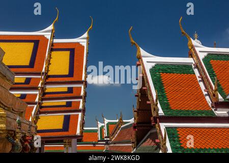 Dettaglio del tetto degli edifici presso il Tempio del Buddha di Smeraldo presso il complesso del Grand Palace a Bangkok, Thailandia. Il ho Phra Monthien Tham è sulla sinistra. Foto Stock