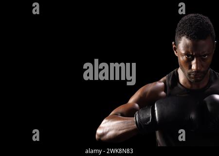 L'uomo afroamericano con equipaggiamento da pugilato posa con fiducia, con spazio di copia Foto Stock