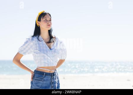 La giovane donna birazziale si erge con cura sulla spiaggia, con spazio per le copie Foto Stock