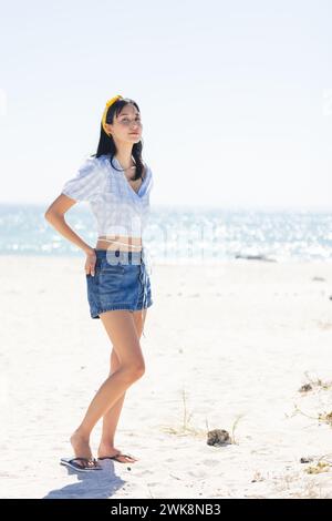 La giovane donna birazziale gode di una giornata di sole in spiaggia con spazio fotocopie Foto Stock