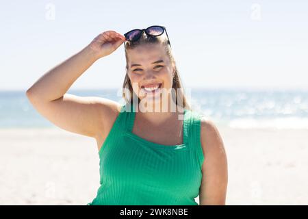 Una giovane donna caucasica di grandi dimensioni gode di una giornata di sole sulla spiaggia Foto Stock