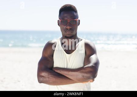 Il giovane afroamericano sta in piedi con fiducia sulla spiaggia Foto Stock