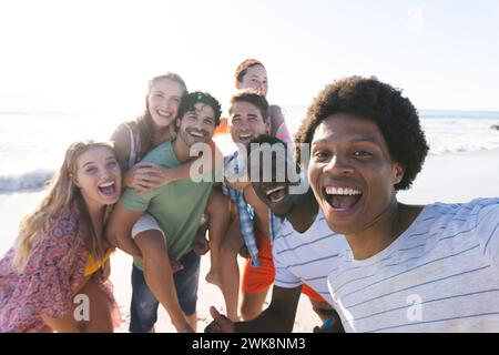 Gruppi diversi di amici che scattano un selfie sulla spiaggia Foto Stock