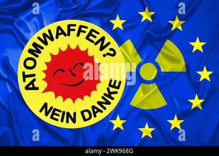 FOTOMONTAGE, Aufkleber mit Aufschrift Atomwaffen - Nein danke auf EU-Fahne mit Radioaktivitätszeichen *** FOTOMONTAGE, adesivo con l'iscrizione armi nucleari no grazie sulla bandiera UE con l'insegna di radioattività Foto Stock