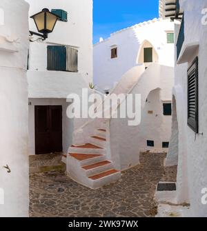 Binibeca Vell, Spagna - 24 gennaio 2024: Cortile con case bianche e scale nel centro del villaggio di Binibeca Vell Foto Stock