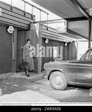 Il primo motel svedese 1956. Il primo motel svedese che si trovava vicino all'autostrada E4 a Fruängen, nel sud di Stoccolma. Gli architetti Börge Glahn e Ole Helweg hanno tratto ispirazione dai motel degli Stati Uniti, dove l'auto era al centro e che avete parcheggiato direttamente accanto alla vostra camera d'albergo. Una donna esce dalla sua stanza d'albergo e arriva alla sua macchina. 1956 *** didascalia locale *** © Libreria di immagini classica. Tutti i diritti riservati. Protetto da una firma digitale. Il monitoraggio e la protezione delle immagini sono attivati su questa immagine. La licenza; la presentazione o la newsletter NON include l'utilizzo sui social media. Foto Stock