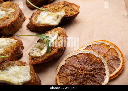 Fette di pane integrale ricoperte da formaggio fuso dorato e rucola fresca da vicino Foto Stock