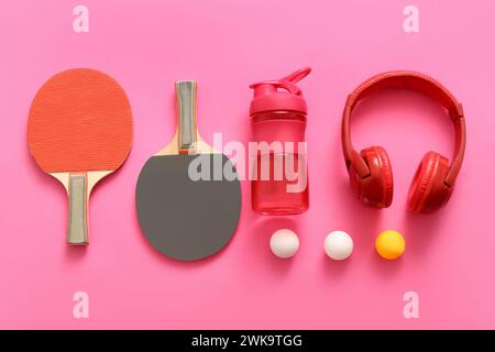 Set di attrezzature sportive con cuffie moderne su sfondo rosa Foto Stock