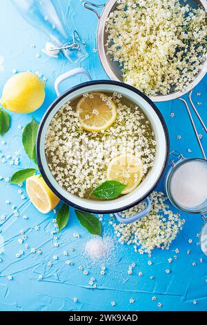 Processo di preparazione di una bevanda estiva, a base di fermentazione naturale dei fiori di anziano in acqua limone e zucchero. Preparazione di uno sciroppo di fiore di sambuco da Foto Stock