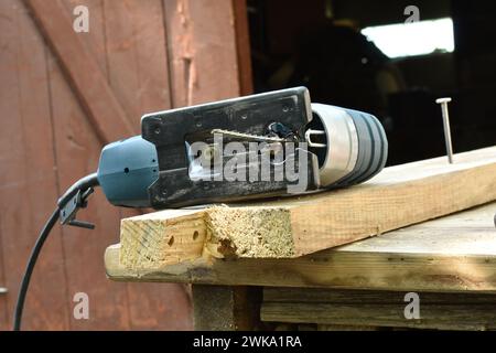 Il falegname ha lasciato il suo utensile chiamato seghetto alternativo, un utensile elettrico per segare il legno, sul banco da lavoro. Foto Stock