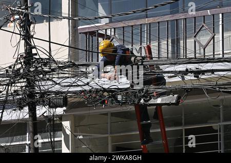 Elektriker auf einer Leiter arbeitet an der massiven Verkabelung im Stadtteil Roma, Mexiko Stadt *** elettricista su una scala che lavora sul cablaggio massiccio nel quartiere Roma, città del Messico Foto Stock