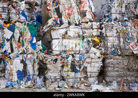 Balle impilate di materiali plastici e di carta riciclabili al centro di smistamento. Foto Stock