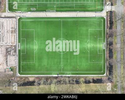 Campo di calcio amatoriale e partita. Persone che fanno esercizio e giocano a football. Vista dall'alto verso il basso dell'antenna sul campo. Erba verde e sport. Foto Stock