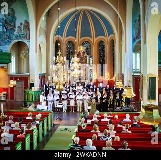 Un coro che si esibisce in una bella chiesa Foto Stock
