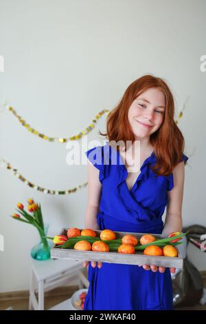 La ragazza con palloncini di polli tiene il piatto con le uova di Pasqua. Vacanze di Pasqua Foto Stock