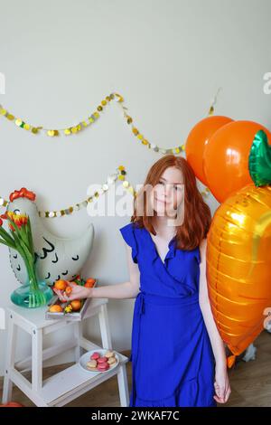 La ragazza con palloncini di polli tiene il piatto con le uova di Pasqua. Vacanze di Pasqua Foto Stock