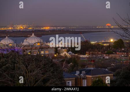 Luna piena che sorge sopra il DP World London Gateway Port con il Siri Guru Nanak Darbar Gurdwara a Gravesend dalla collina dei mulini a vento. Foto Stock