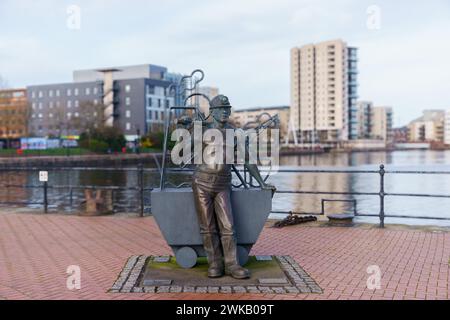 "Dalla fossa al porto" una statua di John Clinch sul lungomare, baia di Cardiff, eretta in omaggio all'industria carboniera del Galles del Sud. Foto Stock