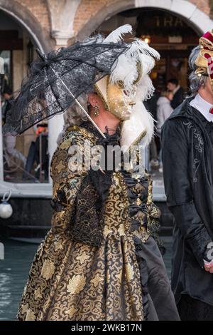 Venezia, Italia - 13 febbraio 2024: Giornata di sole al Carnevale di Venezia con belle maschere. Tradizionali maschere di cartapesta veneziana costruite mâché artigiani Foto Stock