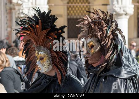 Venezia, Italia - 13 febbraio 2024: Giornata di sole al Carnevale di Venezia con belle maschere. Tradizionali maschere di cartapesta veneziana costruite mâché artigiani Foto Stock