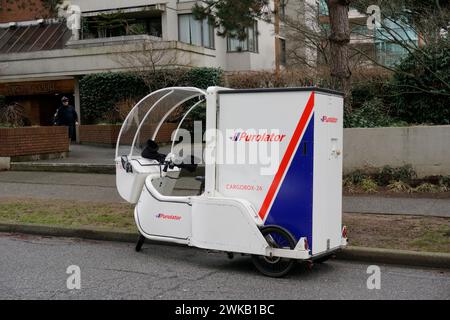 Una bicicletta elettrica Purolator per la consegna del carico parcheggiata in una strada residenziale a Vancouver, BC, Canada Foto Stock