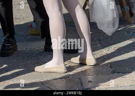 Venezia, Italia - 13 febbraio 2024: Giornata di sole al Carnevale di Venezia con belle maschere e il dettaglio dei piedi e delle gambe di una donna in maschera. Foto Stock