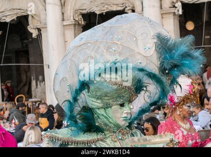 Venezia, Italia - 13 febbraio 2024: Giornata di sole al Carnevale di Venezia con belle maschere. Tradizionali maschere di cartapesta veneziana costruite mâché artigiani Foto Stock