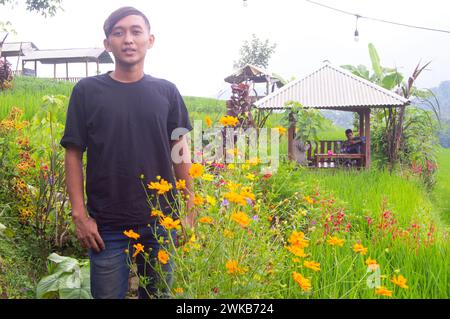 un uomo che indossa una semplice camicia nera in un parco situato nella zona di trawas di ​​mojokerto Foto Stock