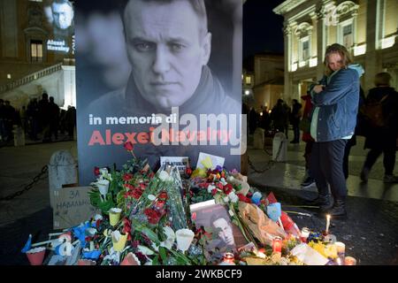 Roma, Italia. 19 febbraio 2024. Una donna guarda la pila di fiori e candele collocate sotto la foto di Alexei Navalny alla processione delle fiaccolate in memoria di Alexei Navalny a Roma. (Credit Image: © Marcello Valeri/ZUMA Press Wire) SOLO PER USO EDITORIALE! Non per USO commerciale! Crediti: ZUMA Press, Inc./Alamy Live News Foto Stock