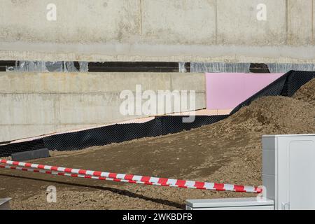 Rivestimenti impermeabili e di isolamento termico a terra applicati sulla parete inferiore della fondazione in una nuova casa in costruzione. Membrane in PVC per edilizia Foto Stock