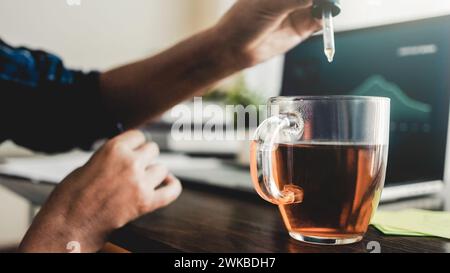 Olio di CBD. Donna d'affari che beve per un trattamento di ansia e stress all'ufficio di lavoro. Medicina alternativa Foto Stock