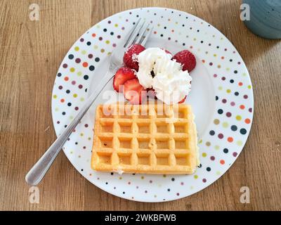 Waffle con fragole e panna su un piatto con una forchetta, Germania Foto Stock