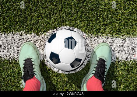 Tiro di un giocatore di calcio in piedi sul campo con palla al centro del campo di calcio Foto Stock