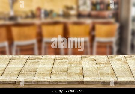Tavolo vuoto in legno e pub bokeh, bar di sfondo ristorante. Foto Stock