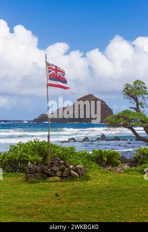 Bandiera delle Hawaii a Kaihalulu Red Sand Beach vicino al villaggio di Hana sulla famosa strada per Hana sull'isola di Maui nelle Hawaii. Foto Stock