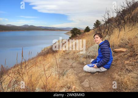 Ragazzo con esigenze speciali con il suo tablet a Carter Lake, Colorado, Stati Uniti Foto Stock