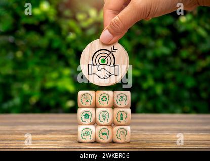 Green Life Society membri della comunità sostenibilità, responsabilità ambientale, conservazione delle risorse. Blocco icona cooperazione in mano messo su woo Foto Stock