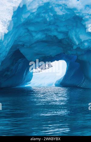 Bagliore blu da una grotta di ghiaccio che penetra attraverso un iceberg, la penisola Antartica, Antartide Foto Stock