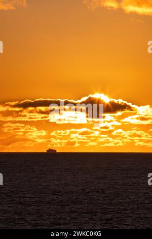 Nave merci che aggira il Capo di buona speranza al largo delle coste del Sudafrica al tramonto. Foto Stock