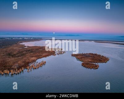 Alba e tramonto lunare sulla foce del fiume Ebro e delle zone umide di Garxal / Garxao e lo Galatxo. Vista aerea (Delta dell'Ebro, Spagna) Foto Stock