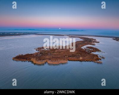 Alba e tramonto lunare sulla foce del fiume Ebro e delle zone umide di Garxal / Garxao e lo Galatxo. Vista aerea (Delta dell'Ebro, Spagna) Foto Stock