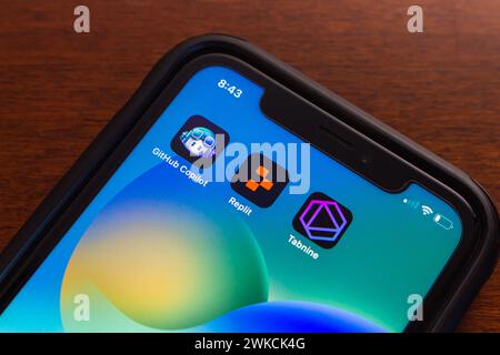 Icone GitHub Copilot, Replit e Tabnine visualizzate sullo schermo dell'iPhone. Tecnologia di intelligenza artificiale generativa, produttività e concetto di cloud computing ai Foto Stock