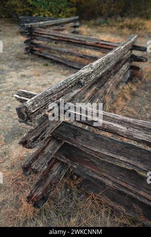 La recinzione della guida a fessura in legno si affievolisce in lontananza. Dividere la recinzione della guida. Recinzione in legno della fattoria Foto Stock