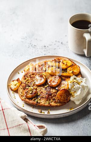 Toast francesi con banana caramellata e pistacchi. Foto Stock