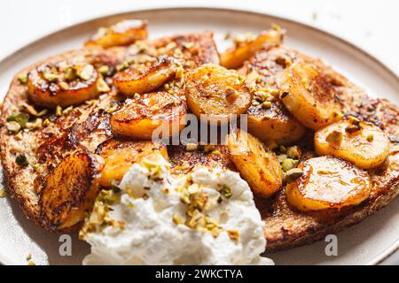 Toast francesi con banana caramellata e pistacchi. Foto Stock