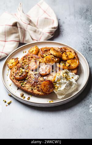 Toast francesi con banana caramellata e pistacchi. Foto Stock