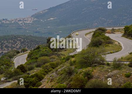 Auto gialla sul tornante tortuoso verso le montagne di Argous Mykines, Peloponneso, Grecia, maggio 2023 Foto Stock