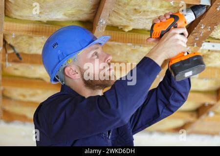 Apprendista operaio edile parete di perforazione Foto Stock