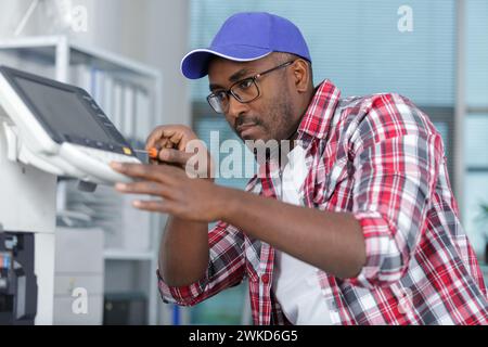 un uomo che fissa la fotoccopiatrice Foto Stock