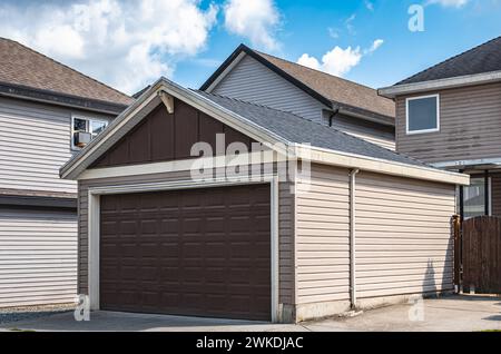 Garage indipendente di casa residenziale con strada asfaltata di fronte. Porta del garage a Vancouver, Canada. Nessuno, foto di strada Foto Stock